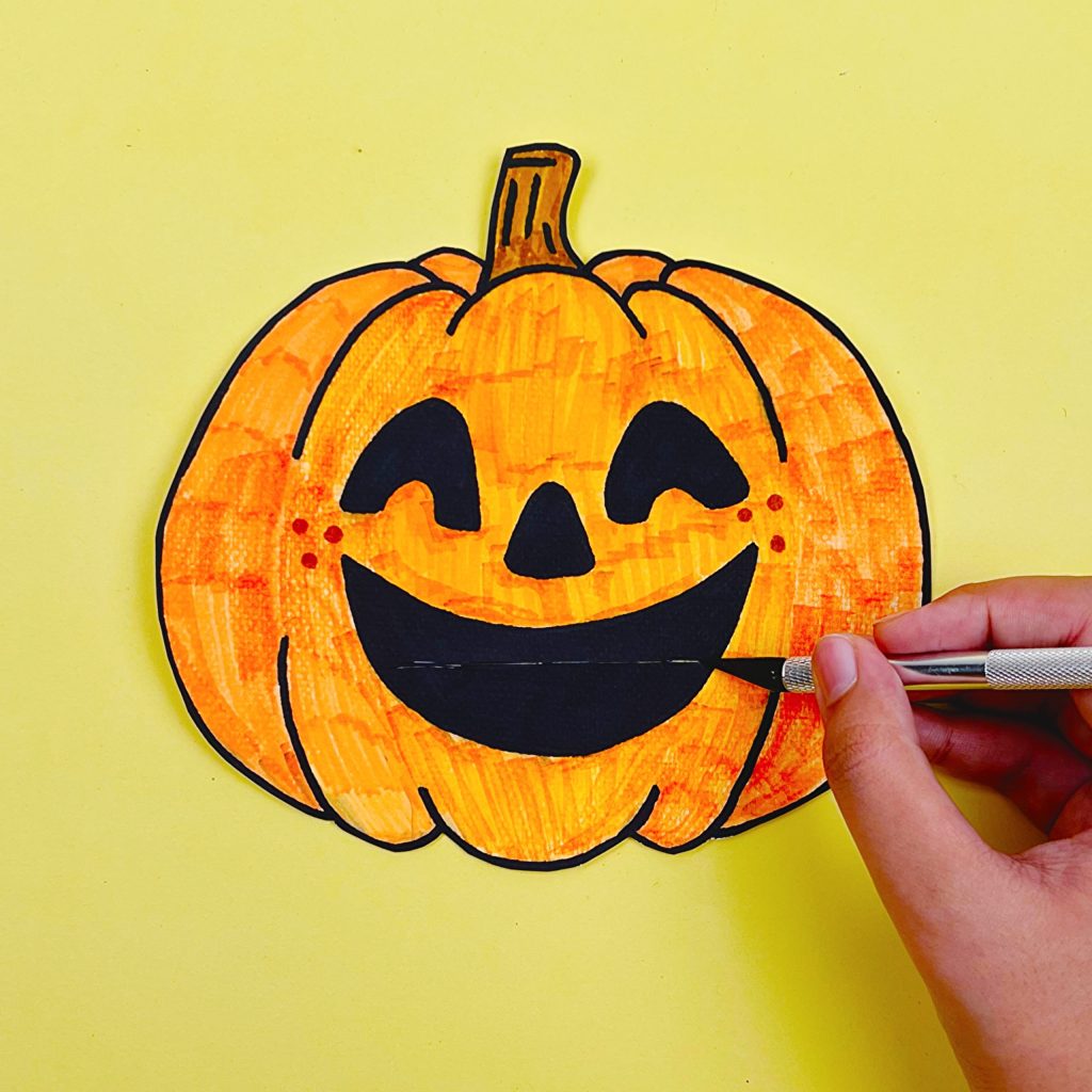 A cut-out pumpkin drawing with a clean mouth slit prepared for the Peek-a-Boo feature.