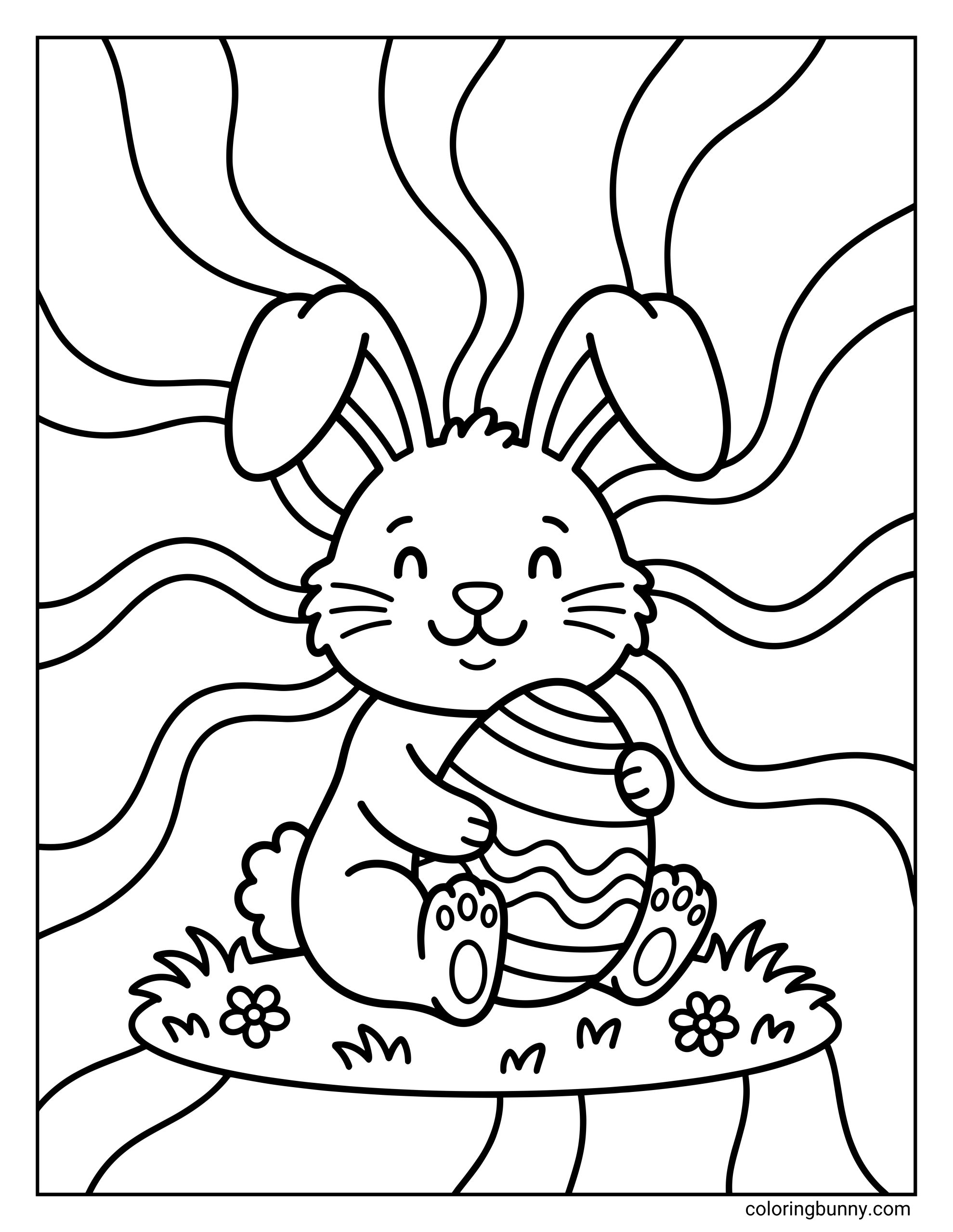 A kids coloring page of a smiling Easter bunny sitting on grass and hugging a decorated Easter egg, with wavy radiating lines in the background and small flowers around the bunny.